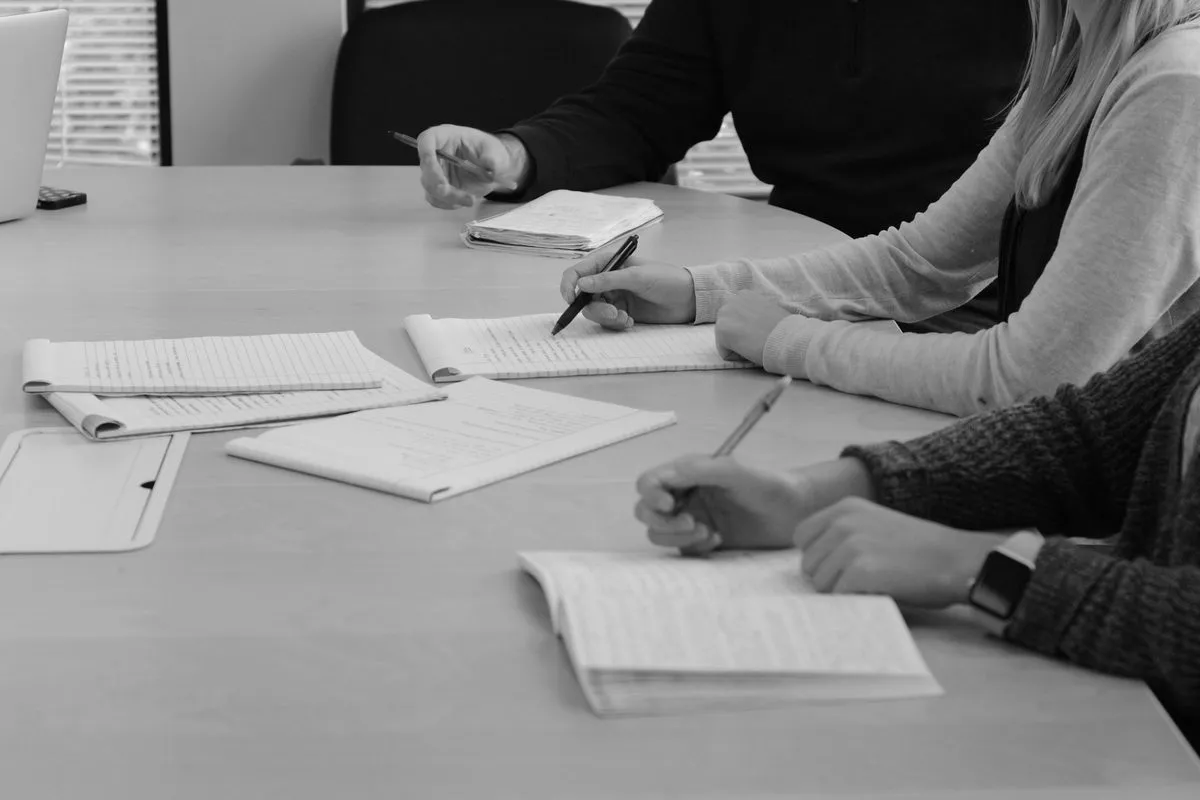 people writing at a desk